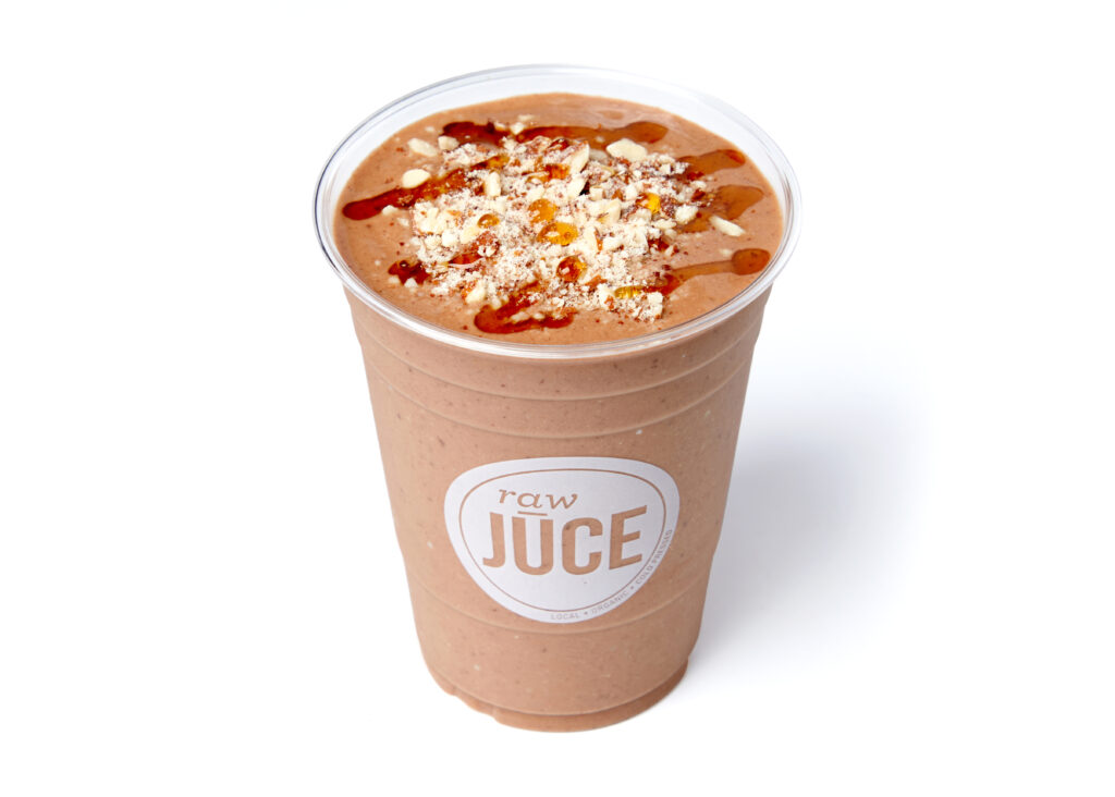 Four chocolate smoothies made with cacao, banana, protein, and almond mylk, garnished with almonds.