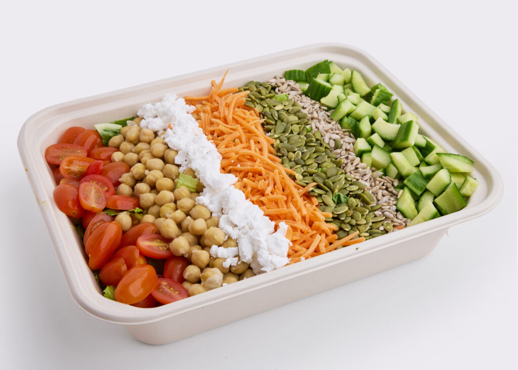A vibrant cobb salad with cherry tomatoes, chickpeas, cucumber, and maple balsamic dressing.