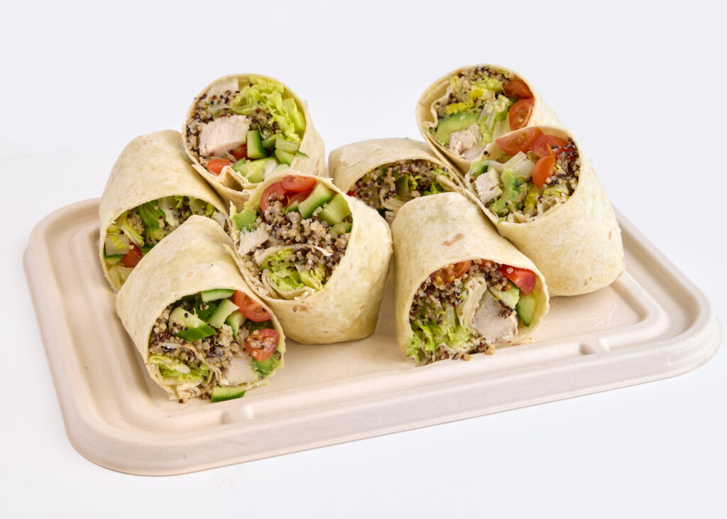 Fresh chicken wraps with avocado, cucumbers, and cashew ranch dressing, cut in halves.